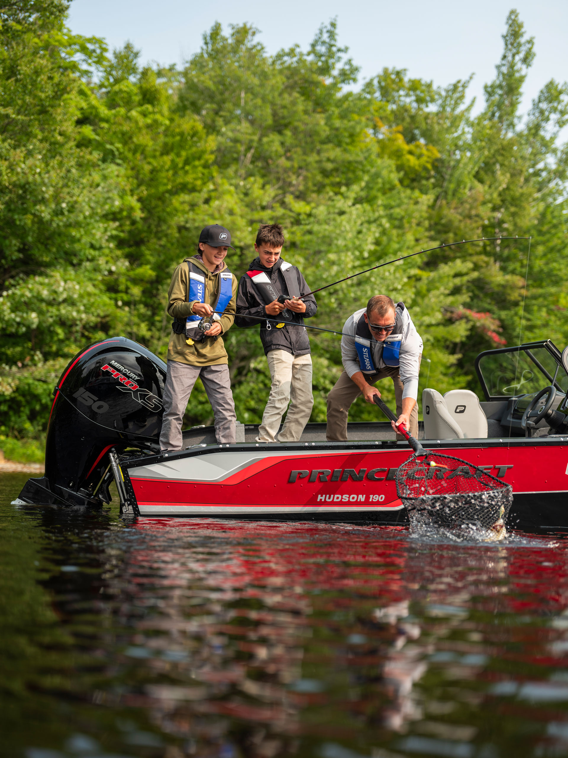 Father and sons catching a fish on a Princecraft